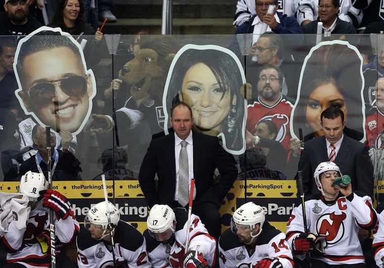 LOS ANGELES, CA - JUNE 04:  Head Coach Peter DeBoer (C) and Assistant Coach Adam Oates (R) of the New Jersey Devils look on from the bench area in front of cardboard cut-outs of the cast members of Jersey Shore in the first period of Game Three of the 2012 Stanley Cup Final against the Los Angeles Kings at Staples Center on June 4, 2012 in Los Angeles, California.  (Photo by Bruce Bennett/Getty Images)